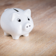 white piggy bank on brown wooden surface