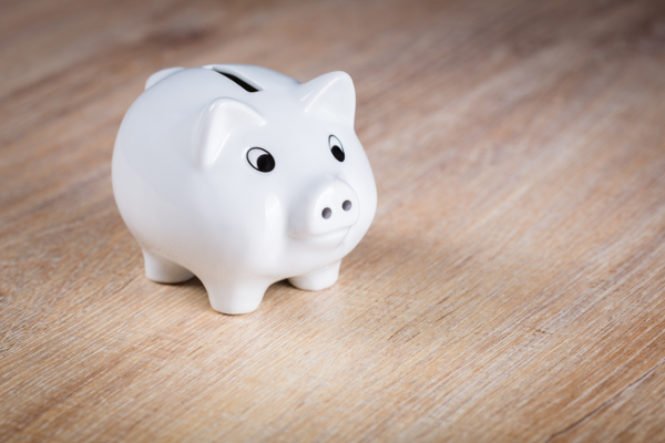 white piggy bank on brown wooden surface