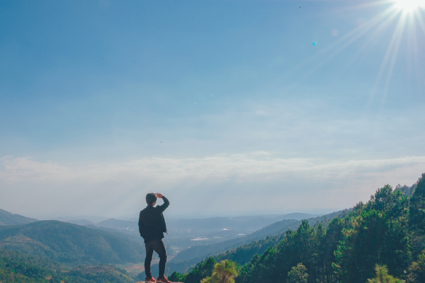 Man Looking From a Cliff at Mountains and Horizon